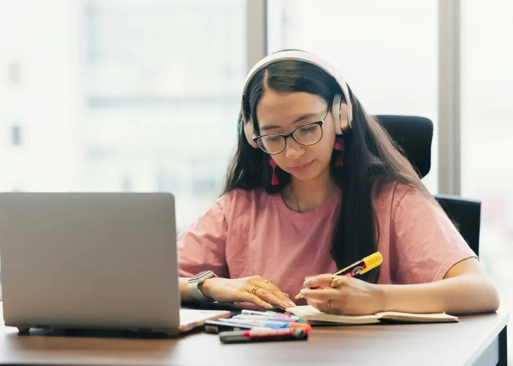 Adult learner wearing headphones and studying at a desk