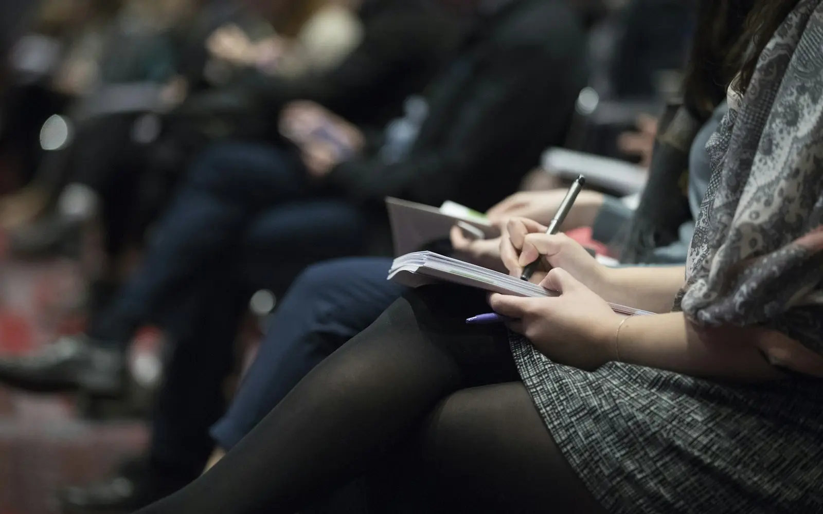 Adults taking notes during a learning session