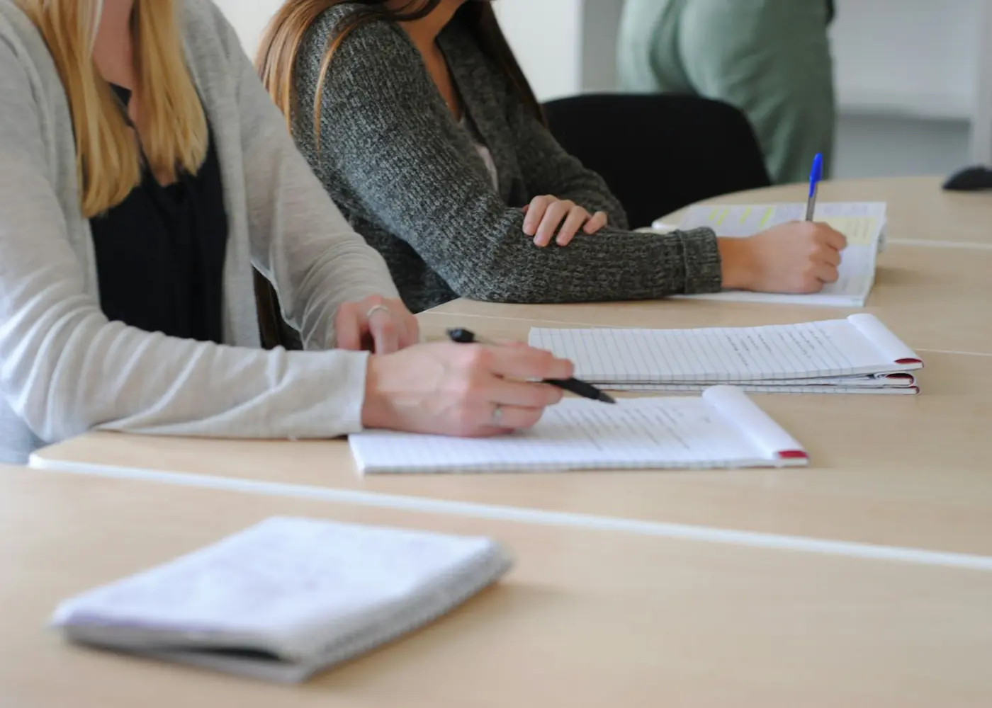 Adult writing notes on paper at a desk