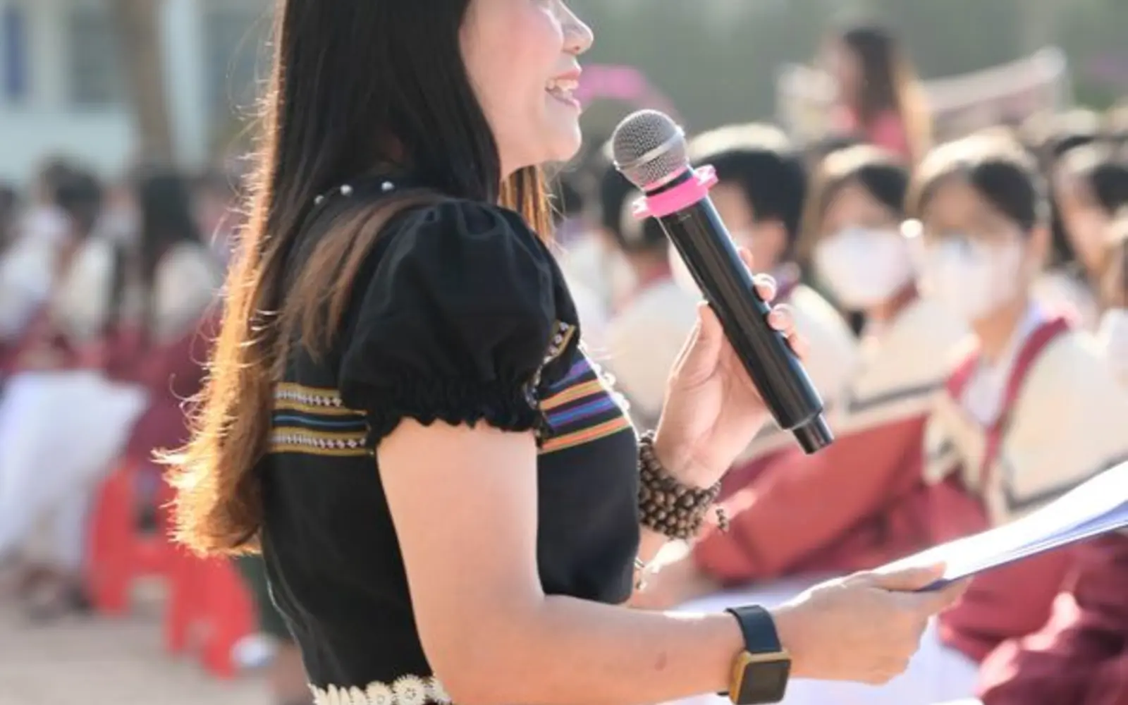 An Asian woman speaking into a microphone