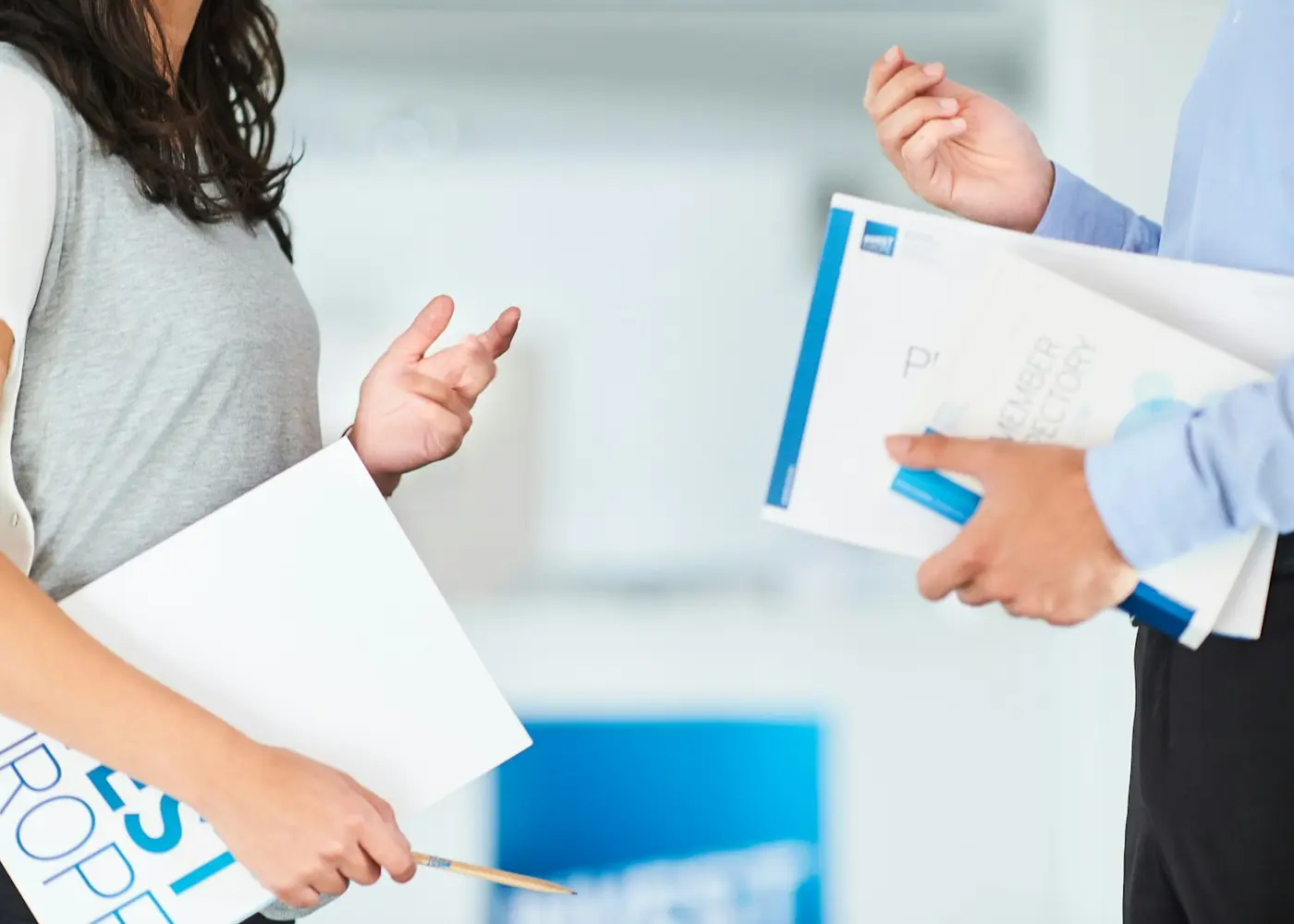 Two business professionals discussing documents after a presentation